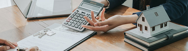 agent holding a calculator with miniature house