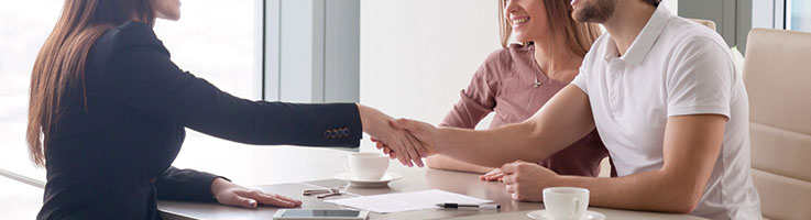 lender shaking hands with couple
