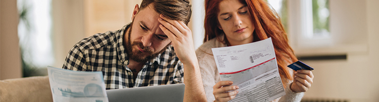 worried couple looking at bills