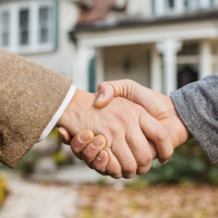 handshake in front of a new house