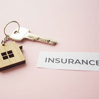 house keychain with key and insurance paper