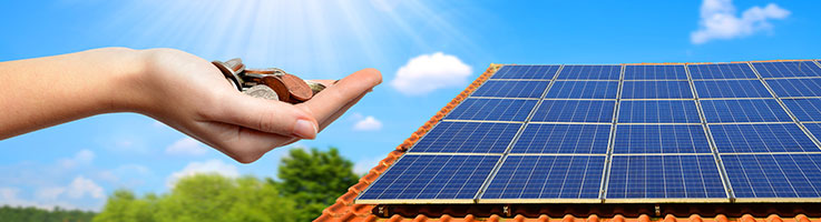 solar panel on the roof of a house and a hand holding some coins