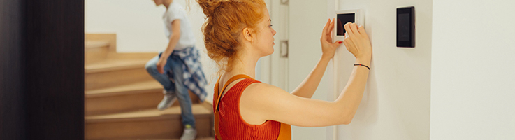 woman checking home alarm