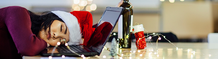 woman wearing santa hat asleep at computer