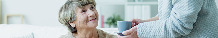 Person bringing coffee to a senior