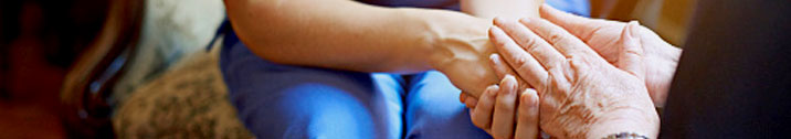 Caregiver and patient holding hands