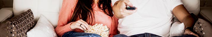 Couple watching tv eating popcorn