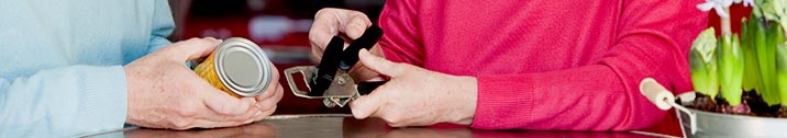 Elderly woman using can opener