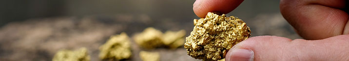 Fingers holding gold nugget