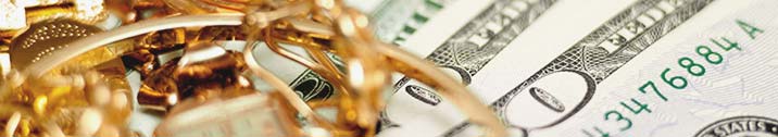 Gold jewelry on top of bills