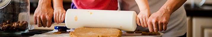 Father and child using a rolling pin