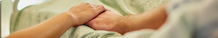 Holding hands in hospital bed