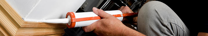 Man caulking base boards