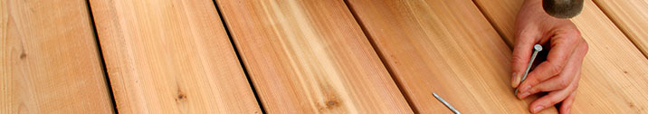 Person hammering nail in deck