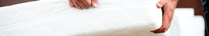 Person holding up white mattress
