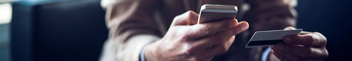 Man looking at phone and credit card