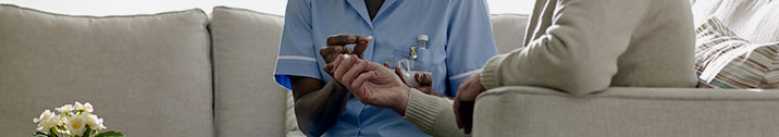 Nurse giving elderly patient medicine