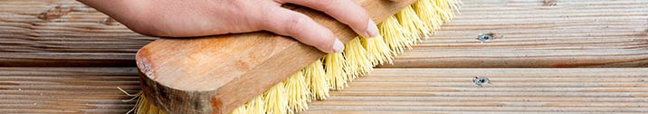 Person scrubbing deck with a brush