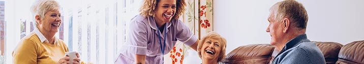 Senior adults laughing together with nurse