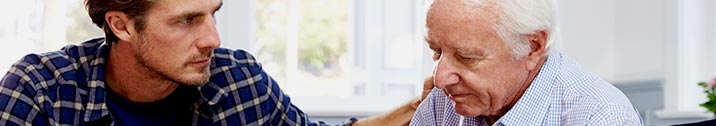 Son comforting elderly father