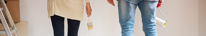 Couple holding painting supplies