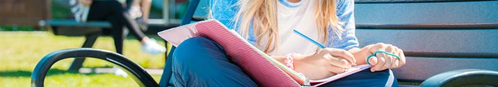 Girl studying on park bench