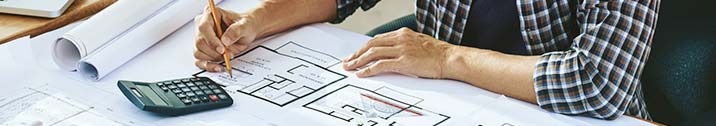 Person with calculator and house blueprints