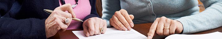 Woman and senior parent signing document