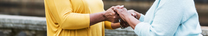 Woman holding hands with senior parent