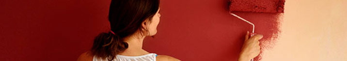 Woman painting wall with red paint