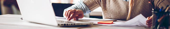 Woman with laptop and paperwork