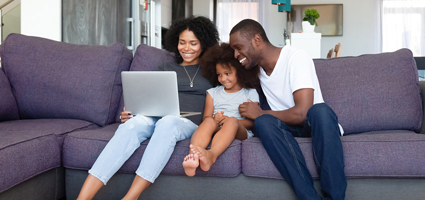 family on couch with laptop